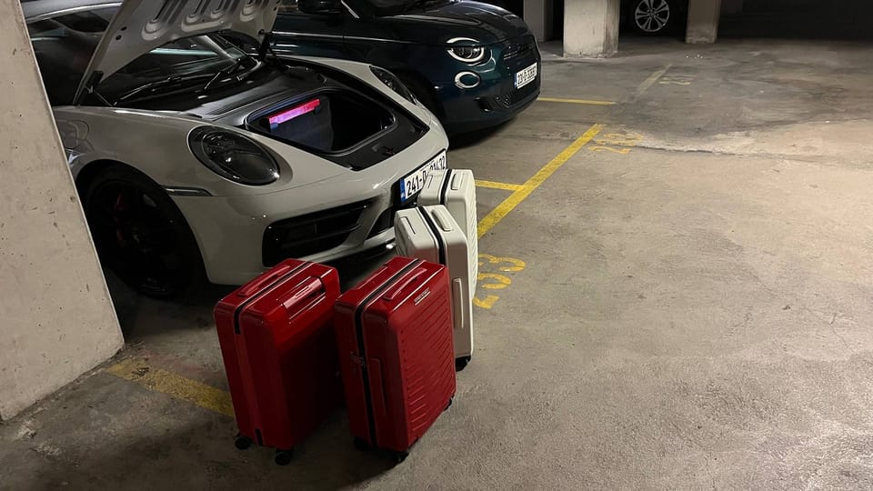 Porsche Design luggage in front of Porsche 911 frunk